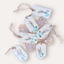 Load image into Gallery viewer, Seaside Oasis Sachets by Pure Essence Scent-white scented wax decorated with dried botanicals and pebbles for decoration, and twine loop for hanging.