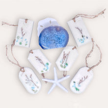 Load image into Gallery viewer, Seaside Oasis Sachets by Pure Essence Scent-white scented wax decorated with dried botanicals and pebbles for decoration, and twine loop for hanging.