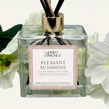 Load image into Gallery viewer, Pleasant Sunshine Reed Diffuser by Pure Essence Scent-A glass reed diffuser filled with scented liquid. There’s a gold cap and black/natural reeds, some featuring decorative flowers.