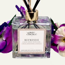 Load image into Gallery viewer, Refreshe Reed Diffuser by Pure Essence Scent-A glass reed diffuser filled with scented liquid. There’s a gold cap and black/natural reeds, some featuring decorative flowers.