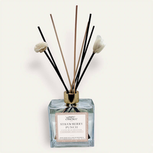 Load image into Gallery viewer, Strawberry Punch Reed Diffuser by Pure Essence Scent-A glass reed diffuser filled with scented liquid. There’s a gold cap and black/natural reeds, some featuring decorative flowers.