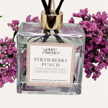 Load image into Gallery viewer, Strawberry Punch Reed Diffuser by Pure Essence Scent-A glass reed diffuser filled with scented liquid. There’s a gold cap and black/natural reeds, some featuring decorative flowers.